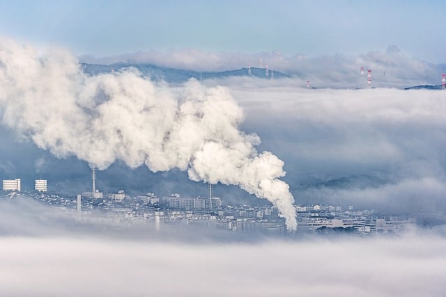 Klimawandel als Herausforderung Eine versmogte Landschaft mit dem rauchenden Kamin eines Grossbetriebs – ein Sinnbild dafür, wie unser Konsum den Klimawandel antreibt.